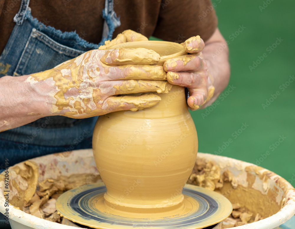 Clay craftsman sculpts crockery . Close-up.