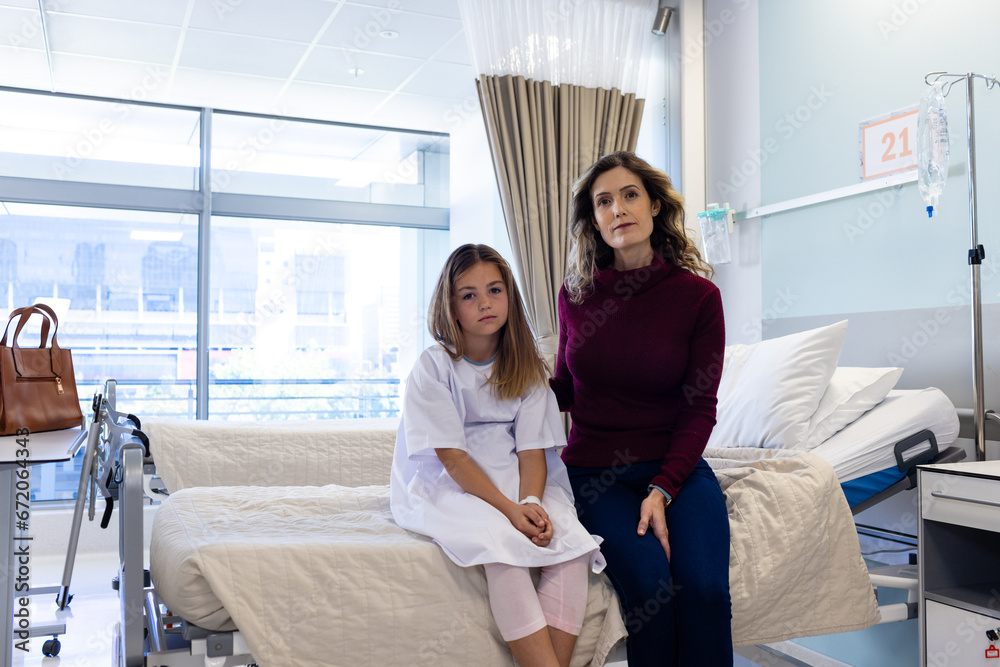 Portrait of caucasian mother and sick daughter patient sitting on hospital bed, copy space Portrait of caucasian mother and sick daughter patient sitting on hospital bed, copy space