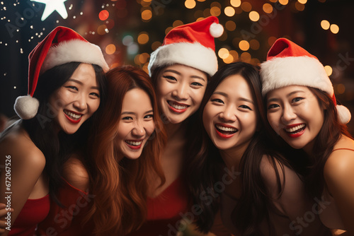 group shot of beautiful Asian young women in santa hats at night party