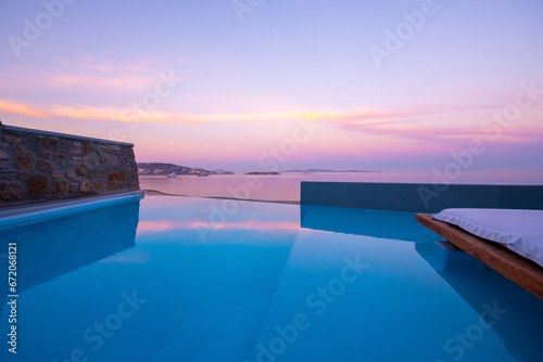 Infinity swimming pool in the villa at sunset time, Mykonos, Greece