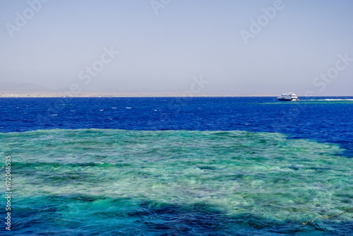 amazing coral reef with clear blue water and a white boat