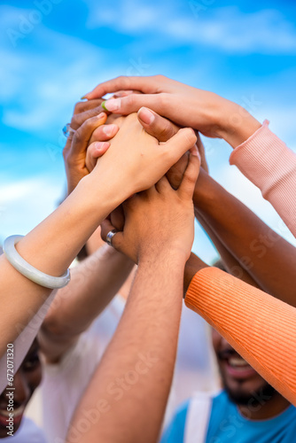 Vertical photo of hands of multi-ethnic people joining