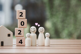 2024 Happy New Year. Happy family, Budget planning, Insurance, House and Real estate, Plan and saving money for future. Human figure family with smiling face and heart with wooden blocks number 2024.