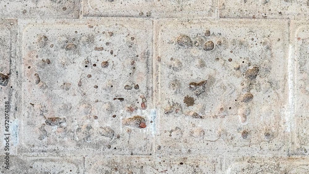 Texture of a gray concrete wall with traces of dismantled facing tiles