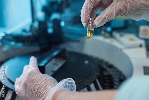 Researcher, doctor, scientist or laboratory assistant working with a glass flask on a centrifuge in a modern laboratory or hospital