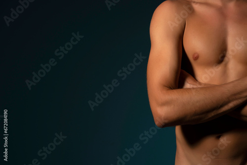 the torso of a young athletic guy. concept: the male body after exercise and diet. men's health: shaved breasts on a dark background photo