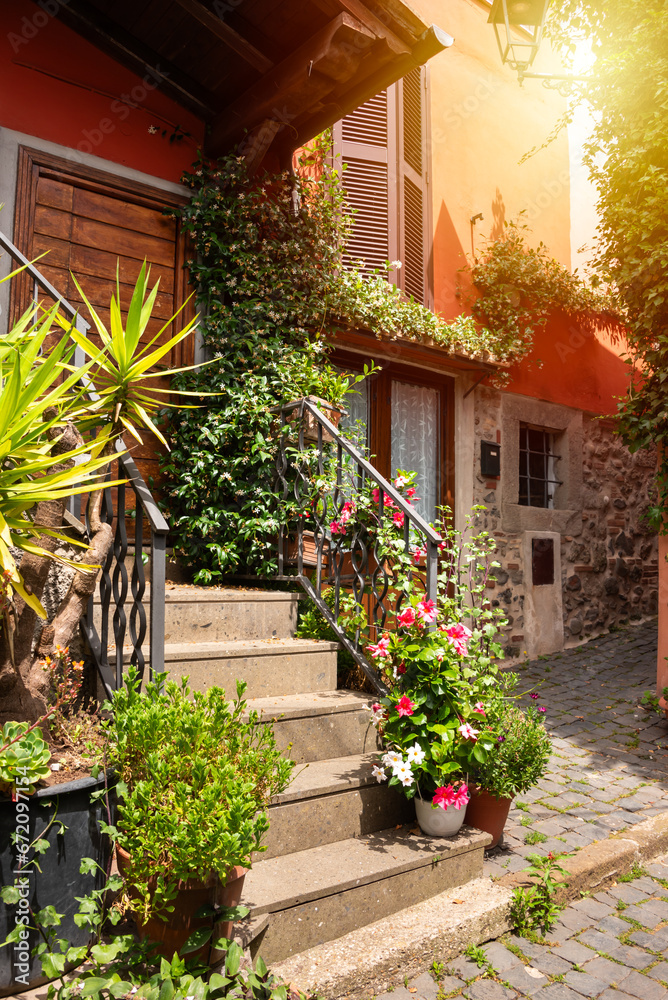 Narrow street of small town with many flowers in Italy