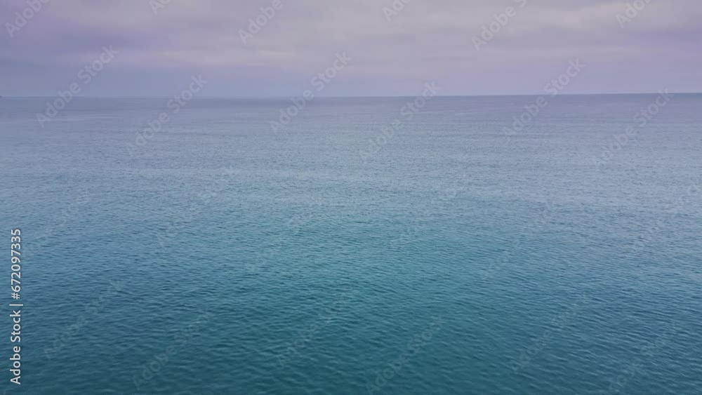 Aerial view of a drone flying over a calm sea early in the morning Aerial view of a drone flying over a calm sea early in the morning