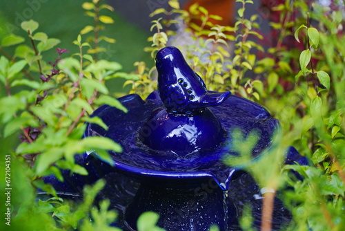 Dark blue ceramic fountain in the garden.
