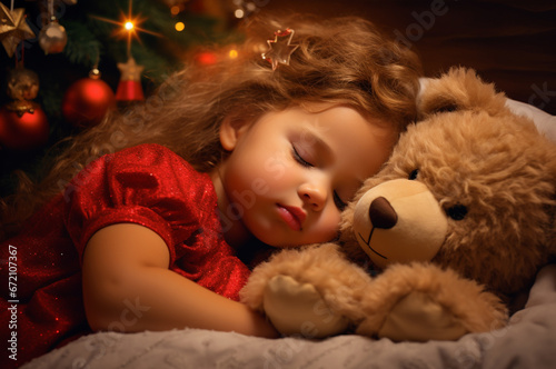 A girl in a red dress fell asleep under a Christmas tree with a teddy bear after Christmas