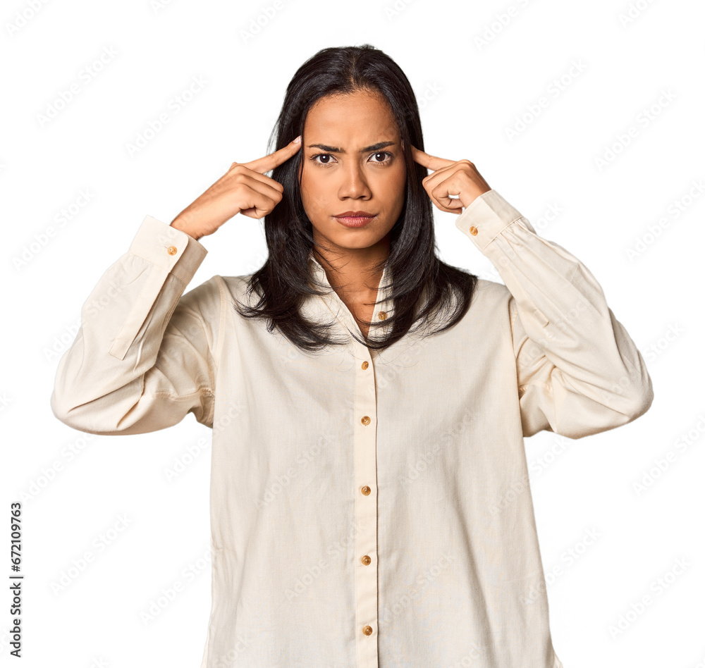 Young Filipina with long black hair in studio focused on a task, keeping forefingers pointing head.