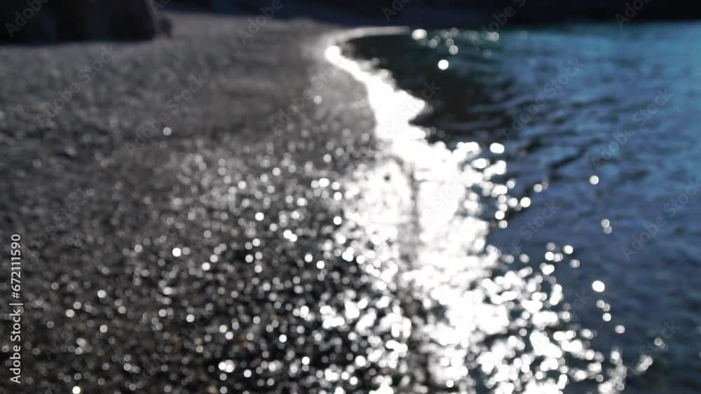 Abstract calm sea summer ocean sunset nature background. Small waves on water surface in motion blur with golden bokeh lights from sun. Holiday, vacation and recreational concept. Slow motion