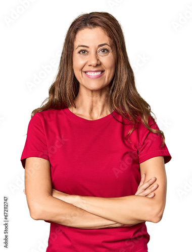 Middle-aged woman portrait in studio setting who feels confident, crossing arms with determination.