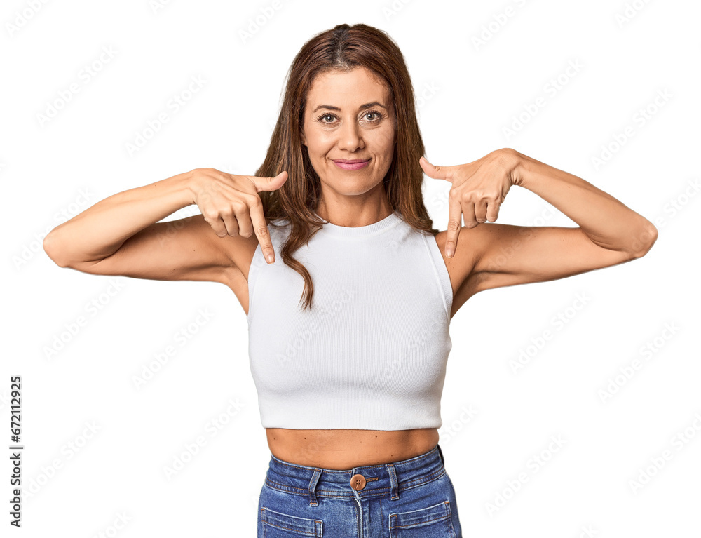 Middle-aged woman portrait in studio setting points down with fingers, positive feeling. Middle-aged woman portrait in studio setting points down with fingers, positive feeling.