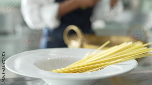 Close-up shot.  Hand moved spaghetti and dipped in the pot of boiling water. cooking pasta. hot water steam. food preparation in the kitchen. front view. photo