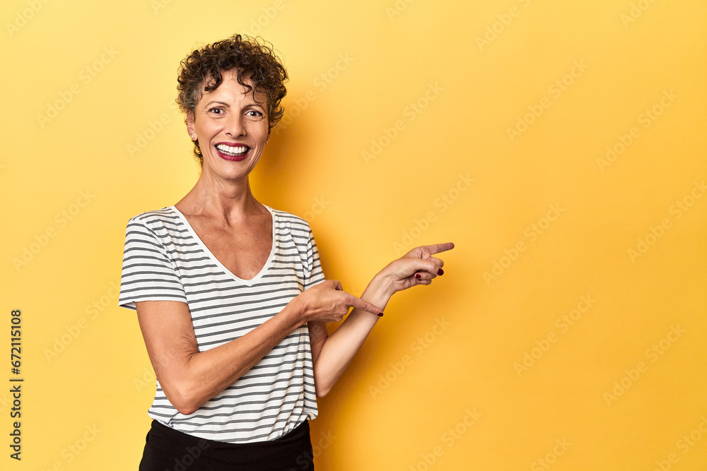 Mid-aged caucasian woman on vibrant yellow excited pointing with forefingers away. Mid-aged caucasian woman on vibrant yellow excited pointing with forefingers away.