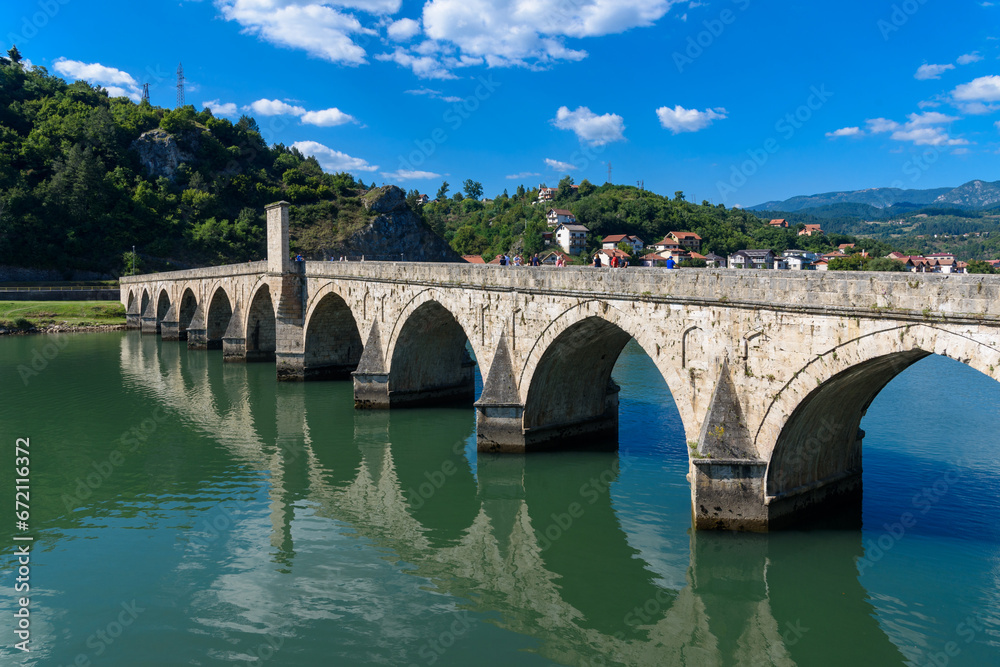 Naklejka premium Visegrad, Bosnia and Herzegovina - August 13, 2023: Famous bridge on the Drina in Visegrad, Bosnia and Herzegovina. Mehmed Pasa Sokolovic Bridge on Drina River