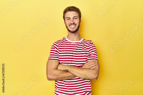 Wallpaper Mural Young Caucasian man on a yellow studio background who feels confident, crossing arms with determination. Torontodigital.ca