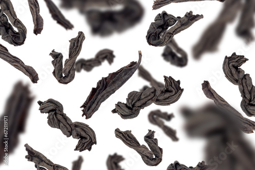 Levitation of dry black tea leaves isolated on a transparent background.