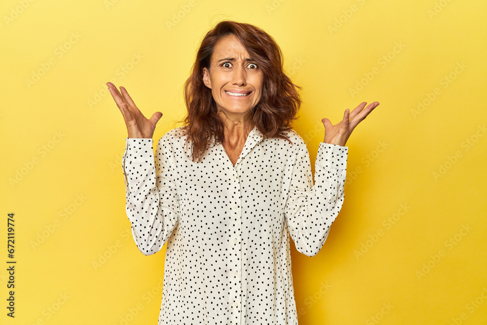 Middle-aged woman on a yellow backdrop screaming to the sky, looking up, frustrated. Middle-aged woman on a yellow backdrop screaming to the sky, looking up, frustrated.