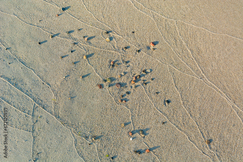 Small rocks and wave marks in the sand. Sea or ocean beach.