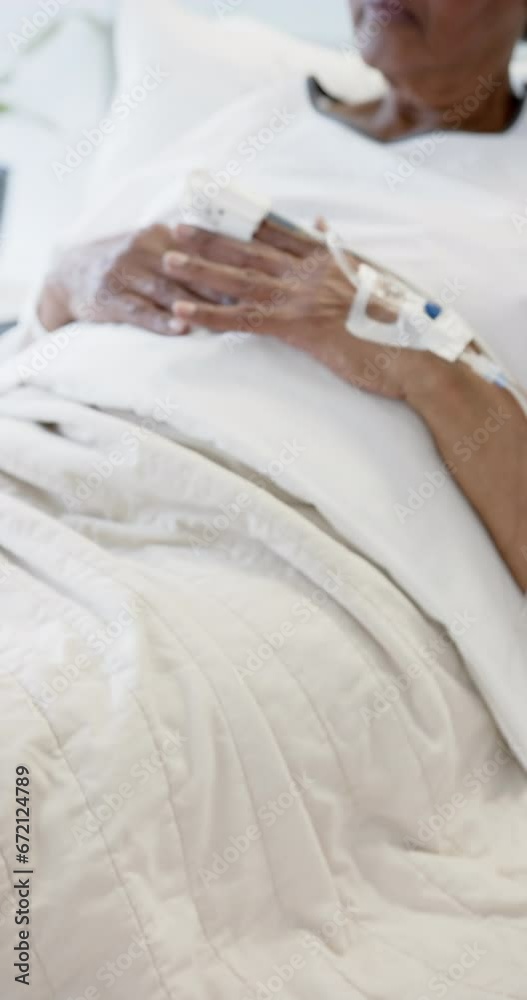 Vertical video of senior african american woman hand with intravenous, slow motion, copy space