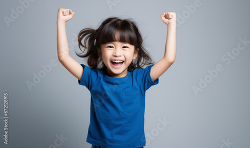 A 6-8 year old Asian girl, looking good and cheerful, stood with her arms raised in great joy, In the clear background, Generative AI