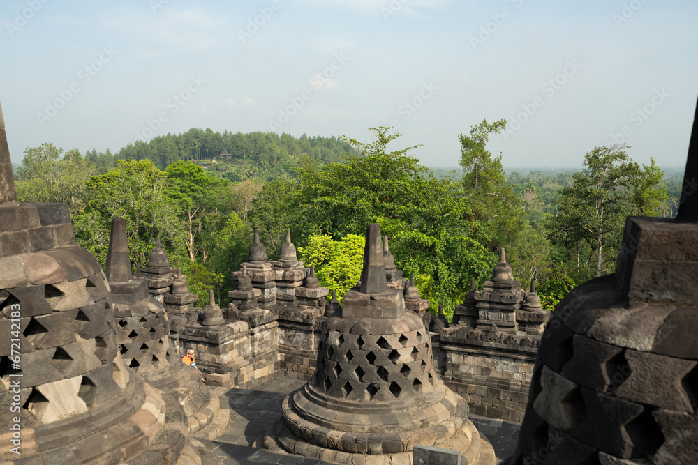 (Selective focus) Stunning view of the Borobudur bell shaped stupas during a beautiful sunrise. Borobudur is a Mahayana Buddhist temple in Magelang Regency in Central Java, Indonesia.