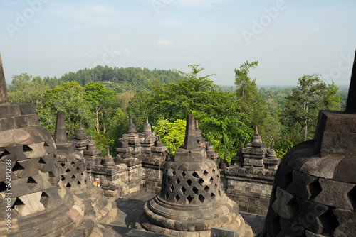 Obraz na płótnie (Selective focus) Stunning view of the Borobudur bell shaped stupas during a beautiful sunrise. Borobudur is a Mahayana Buddhist temple in Magelang Regency in Central Java, Indonesia. w salonie