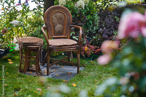 A wicker chair and a stool in the garden.