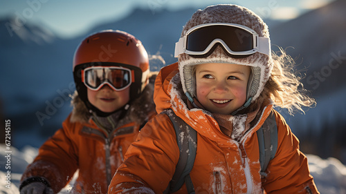 Portrait of little boy and girl in ski suit and helmet sitting on snow