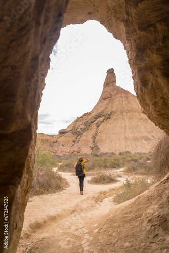 Woman walking alone in the desert through a path