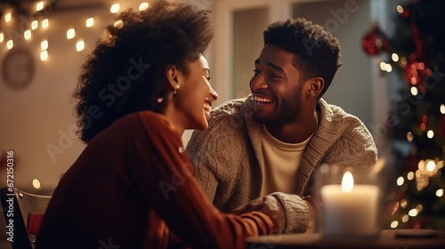 Side see of a blended race man sitting on the floor with his youthful girl in their sitting room at Christmas, grinning and giving a show