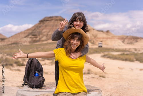 Mother and daughter gesturing success after a trekking in a desert