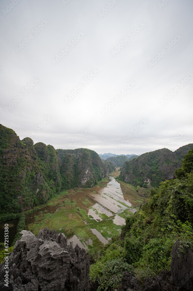 Stunning panorama of Ngo Dong River and the paddy fields below from the Ngoa Long Mountain in Ninh Binh, Vietnam.