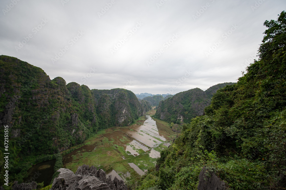 Stunning panorama of Ngo Dong River and the paddy fields below from the Ngoa Long Mountain in Ninh Binh, Vietnam.