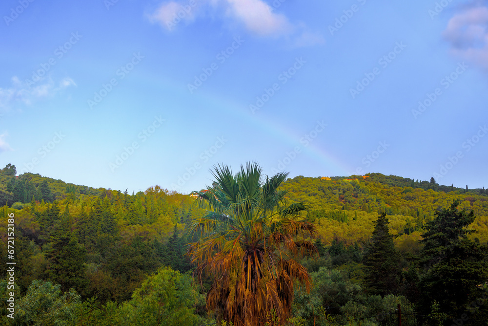 rainbow over  wooded mountains and olive plantations in the north of the island of Corfu