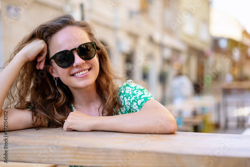 Pretty curly hair young woman enjoying summer in city.