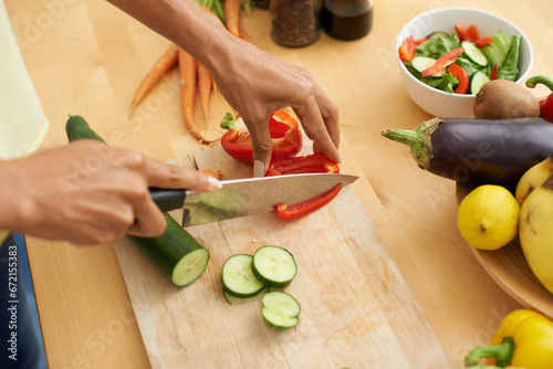 Closeup, hands and cutting with vegetables, nutrition and plant based diet in a kitchen. Person, home and cooking health food, lunch and vegan meal with variety, vitality and weight loss with knife
