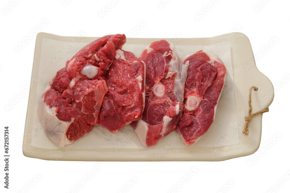 Lamb meat on a ceramic board isolated on white background. Pieces of meat for cooking. Rear part of the meat carcass.