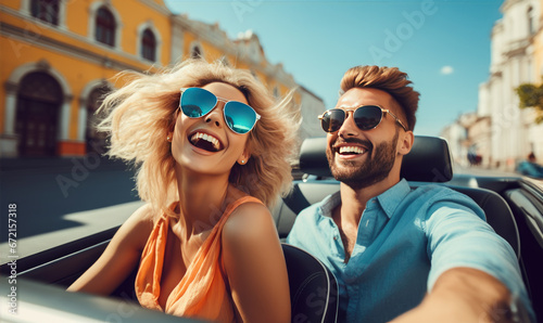 Happy young couple is enjoying ride in a cabriolet car during summer sunny day, active lifestyle concept