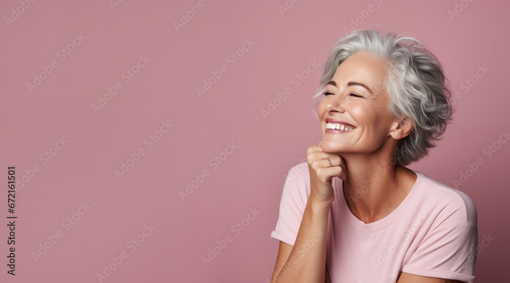 Beautiful happy elderly mature well-groomed woman model 50, 60, 70 years old posing on a pink background - obrazy, fototapety, plakaty 