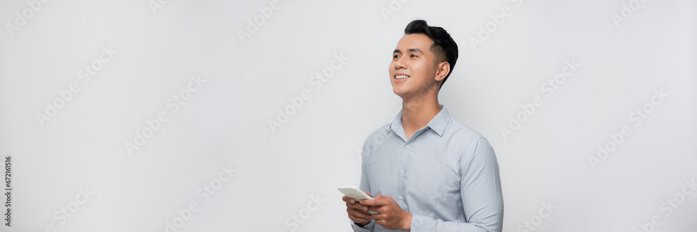 Young smiling handsome Asian man using mobile phone isolated on white background Young smiling handsome Asian man using mobile phone isolated on white background