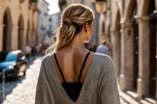 Beautiful blond woman backside walking on a street in Europe