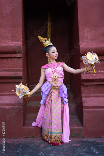 Pretty Asian women wearing beautiful Thai traditional dress in Hundred Thousand Lantern Festival or Yi Peng Festival for worship at Phra That Hariphunchai temple in Lamphun, Thailand. photo