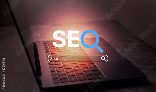 Desk photo with open laptop and VR SEO text interface. SEO Search Engine Optimization concept. Ranking traffic on website. Digital marketing business technology.