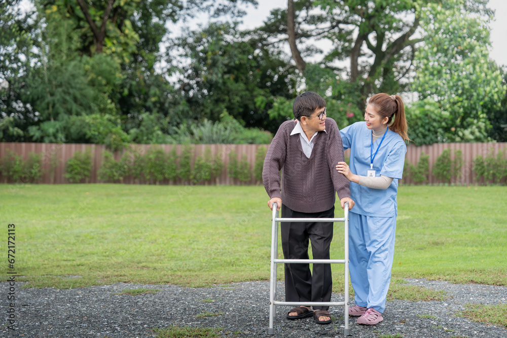 Asian caregiver nurse support senior older male walk outdoors. Specialist girl doctor help and take care of elderly mature man patient doing physical therapy at home Asian caregiver nurse support senior older male walk outdoors. Specialist girl doctor help and take care of elderly mature man patient doing physical therapy at home