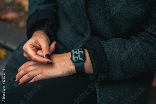 Business woman Looking at smart watch In Park. Gadget technology. © Andrew