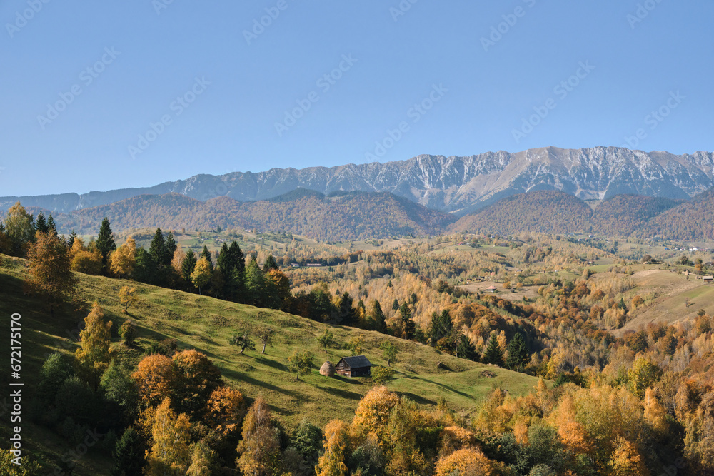 Autumn panorama of mountain village. Autumn Carpathian mountain, Romania. Wonderful autumn rural scenery and colorful birch trees on the hills. Colorful autumn forest on the slope. Transylvania.Europe