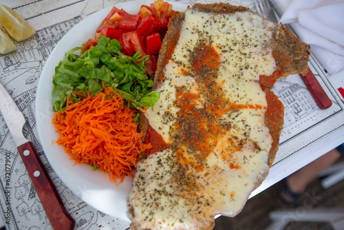 Fotografie, Obraz plate of Milanese with cheese and tomato, carrot and lettuce